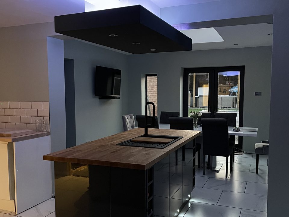Finished kitchen with a dark island and under unit lighting