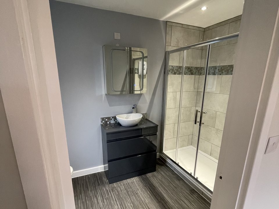 Finished grey shower room with a fitted vanity unit