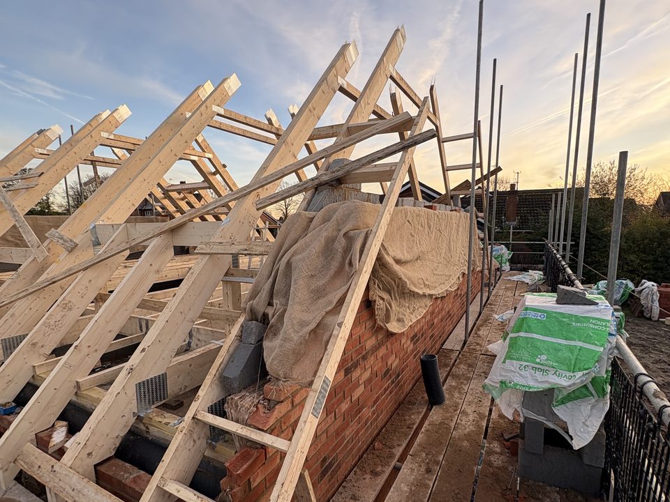 Roof trusses lifted into place at dusk