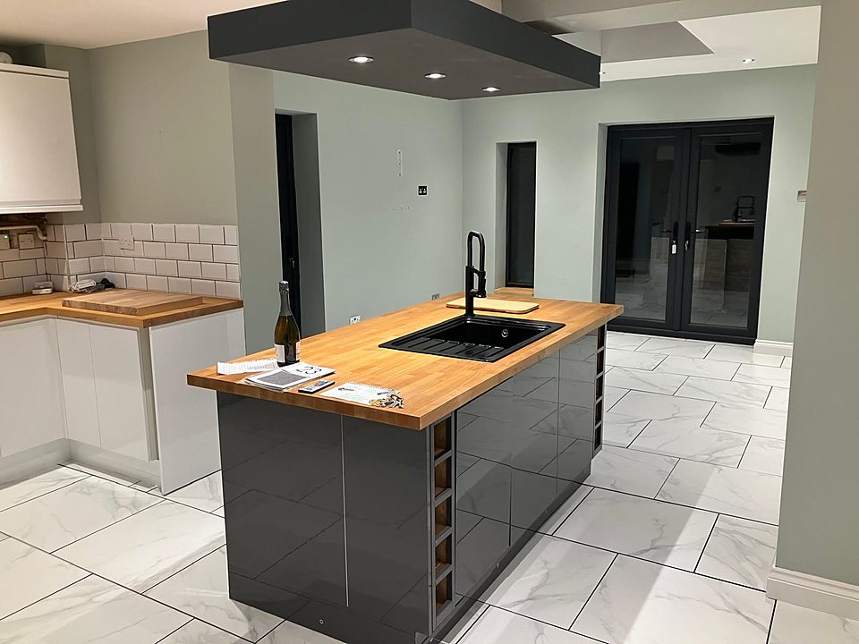Finished kitchen with a grey gloss island and wood worktop