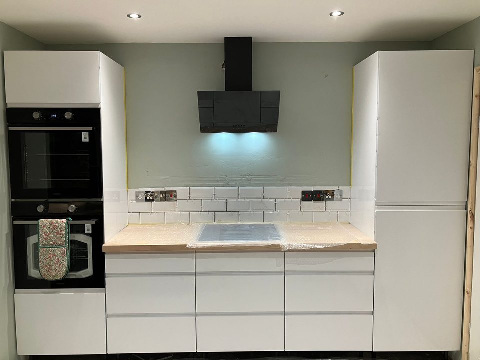 Finished white gloss kitchen with an integrated oven tower
