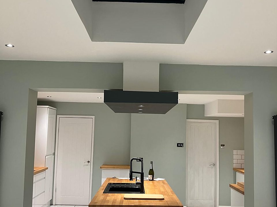 Finished kitchen with a dark island and solid wood worktop